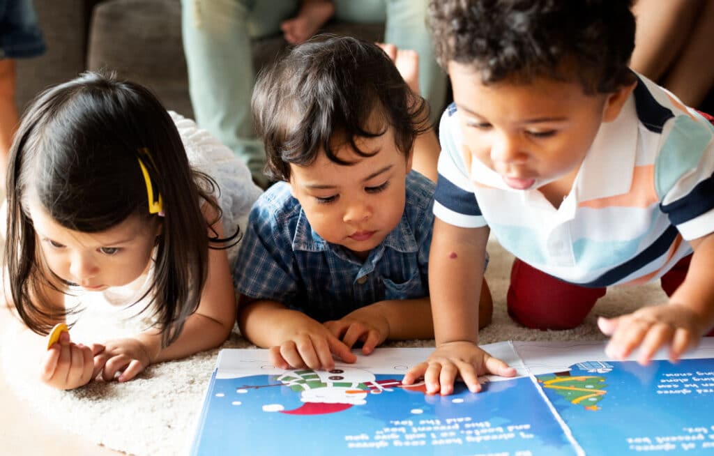 Three toddlers reading a book