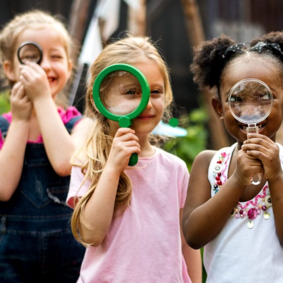 Children exploring the outdoors with magnifying glasses