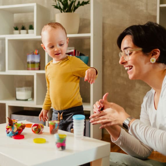 Toddler and teacher playing with modelling clay at daycare